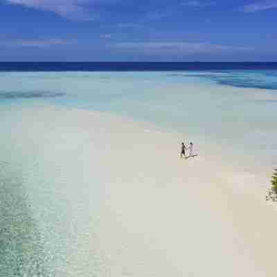 Et par går tur på stranden på Pullman Maamutaa Maldiverne