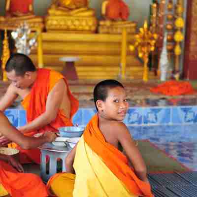 En ung munk har fået øje på kameraet, Laos